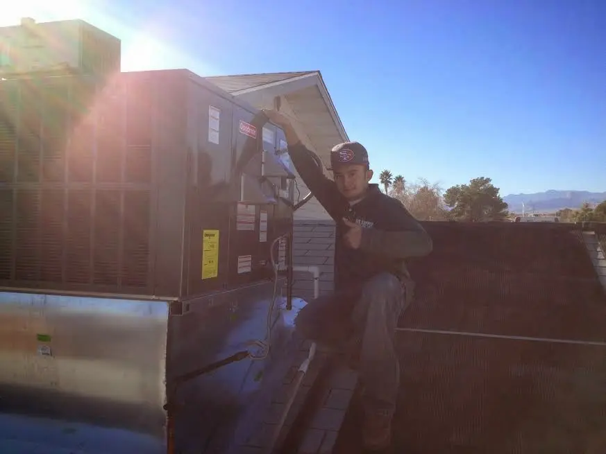 HVAC technician performing Heat Pump Repair on a rooftop unit in Ferndale